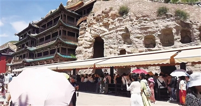 盛夏时节,云冈石窟游客如织。任翔宇摄