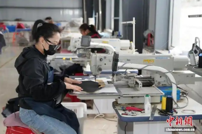 图为五寨县孙家坪乡大辐车梁村箱包厂生产车间，女工们正赶制产品。　刘笃效 摄