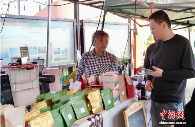 2025年11月26日，游客正在新寨村路边咖啡摊购买咖啡豆。　罗婕 　摄