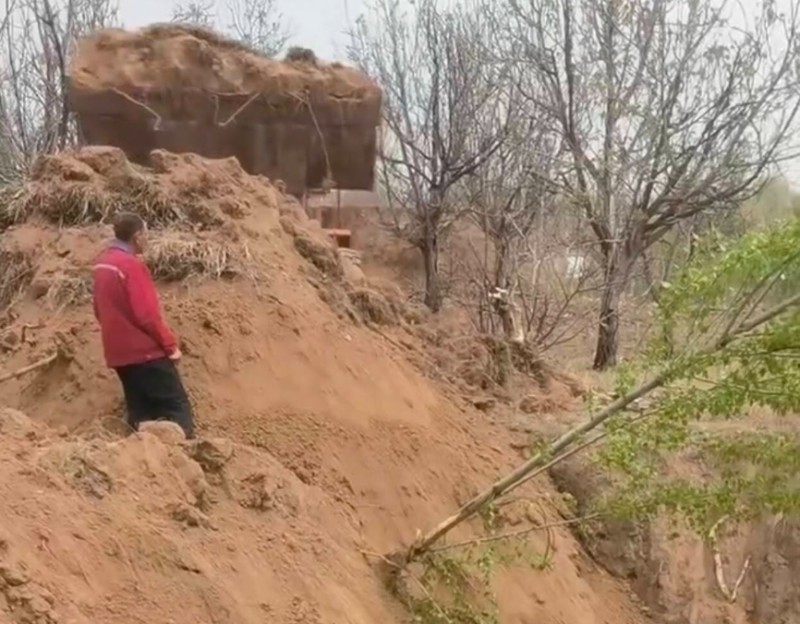 被掩埋前村民站在土堆前制止未果(受访者供图)